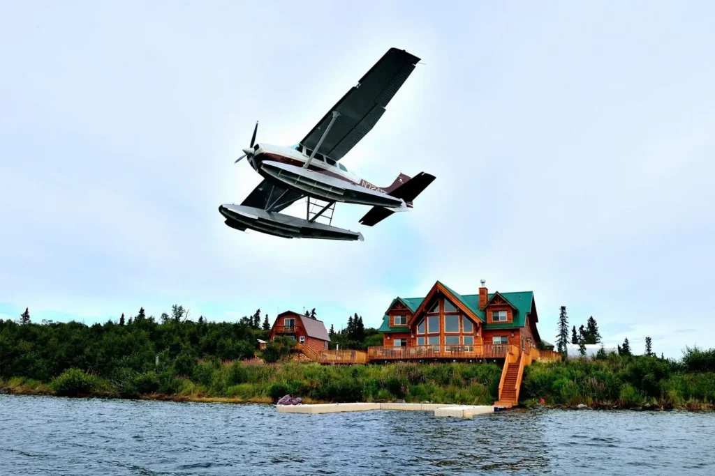 Seaplane flying over lakeside lodge - Intricate Bay Lodge